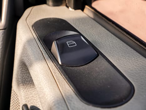 Button for automatic window regulator of the car window. Automatic window regulator. Open and close button. Car side glass. Vehicle. Plastic material. Ventilation in the vehicle interior.