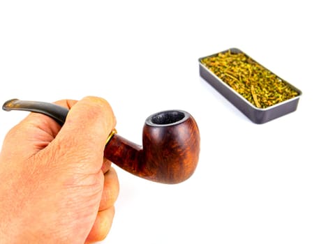 Pipe for smoking tobacco in the hand of a smoker on a white background. Wooden pipe for smoking. Tobacco in a snuffbox. Smokers tool. Human hand. Smoker addiction. Nicotine.