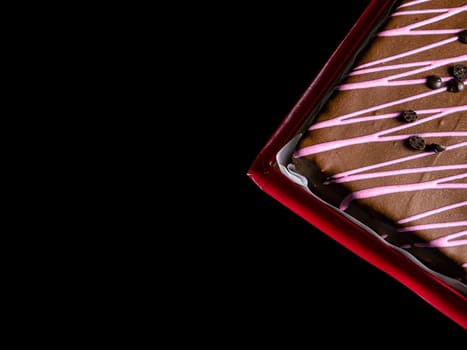 Chocolate cake with pink fruit cream on a black background. Dessert is chocolate. Sponge cream cake. Festive baked goods. Culinary pastries. Sweet food. Sweet dessert. Food photo.