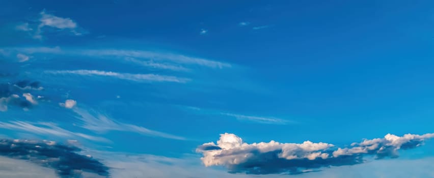 Blue sky with cumulus clouds in sunlight. Blue skies. White cloud. Thundercloud. Summer sunshine. Natural landscape. Comic space. Ecosystem. Cloudy horizon. Natural background.