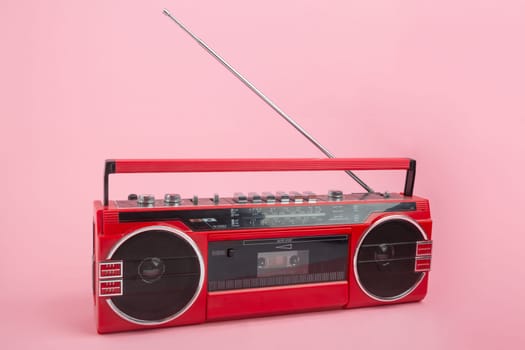 Cassette recorder with opened antenna on pink background