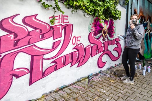 WETZLAR, GERMANY - 23.05.2021: Young female Artist doing artificial typography colorful graffiti senic on house facade in WETZLAR GERMANY