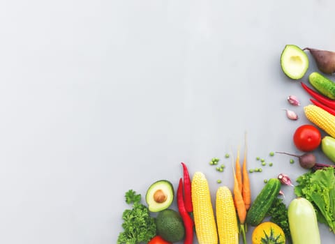 Flat lay with different vegetables, fruits, berries, nuts, spices, herbs, olive oil. Copy space area for some text. Veggies on grey concrete background. Concept of organic bio food healthy eating
