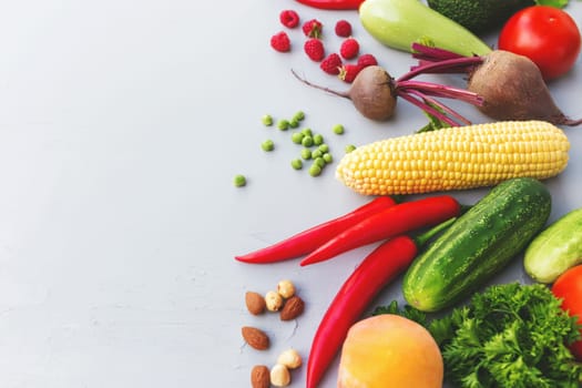 Flat lay with different vegetables, fruits, berries, nuts, spices, herbs, olive oil. Copy space area for some text. Veggies on grey concrete background. Concept of organic bio food healthy eating