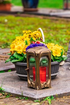 Old damaged grave lantern on a gravestone