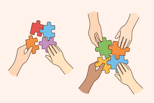 Teamwork, multi ethnic team, cooperation concept. Hands of multicultural people business partners workers colleagues firming whole puzzle of colorful pieces together meaning collaboration
