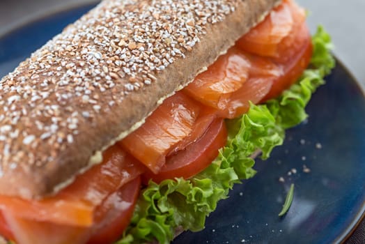 Sandwich with smoked salmon salad and tomato close up. Healthy food
