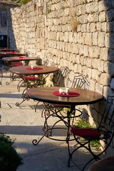 Tables of a restaurant at the historical city wall in the old town of Krk in Croatia