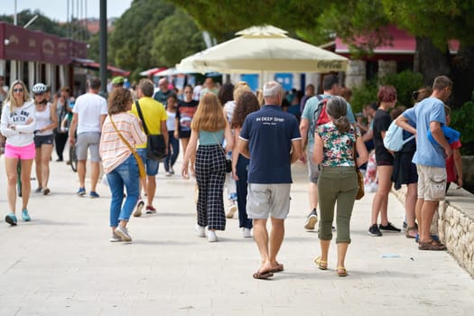 Tourists on the popular promenade in the port of the town of Krk in Croatia