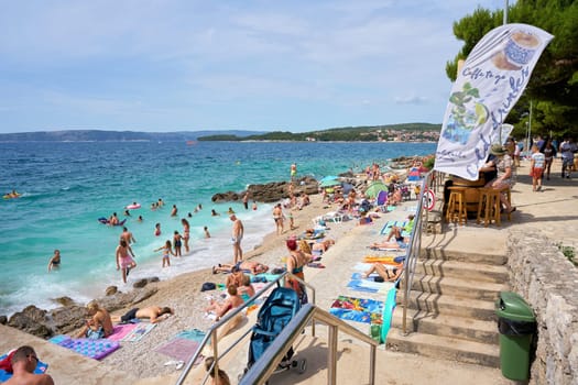 Holidaymakers bathing on the shore of the Adriatic Sea near the town of Krk on the island of the same name in Croatia