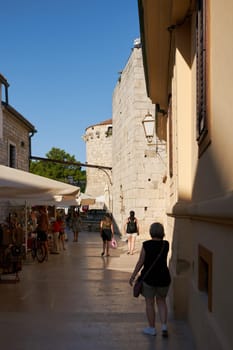 historical alley in the old town of Krk in Croatia. In the background the fortress walls at Kamplin square.