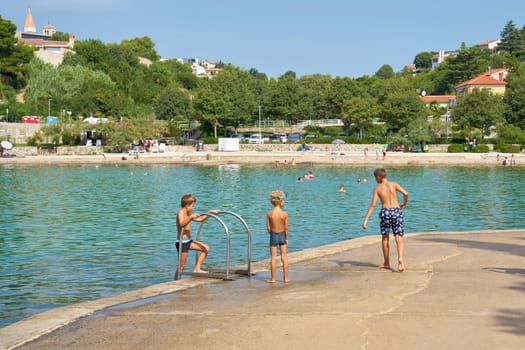 Children playing at a bathing place on the island of Krk near the town of the same name on the Adriatic Sea in Croatia