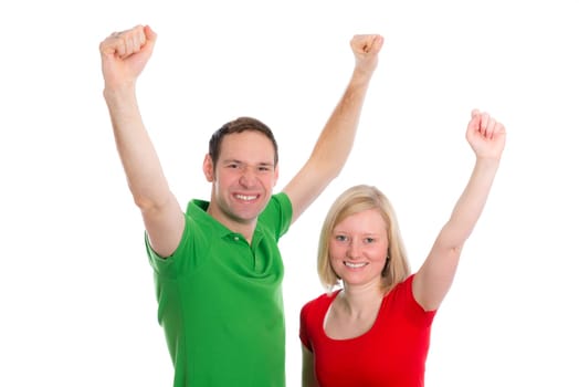 young happy couple in front of white background with arms up
