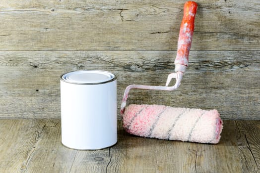roller and paint pot on a wooden table