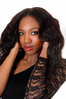 A lovely African American woman in a black blouse standing.in the studio holding her hands on her head, isolated for white background..