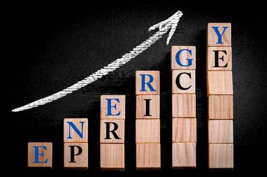 Message ENERGY PRICE on ascending arrow above bar graph of Wooden small cubes isolated on black background. Chalk drawing on blackboard. Business Concept image.