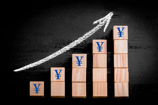 Ascending arrow above bar graph of Wooden small cubes isolated on black background. Chalk drawing on blackboard. Business Concept image.