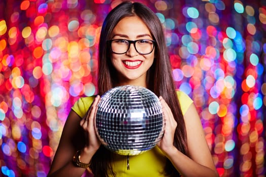 Posh girl in eyeglasses holding disco ball