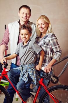 Happy young couple and little boy with bicycle
