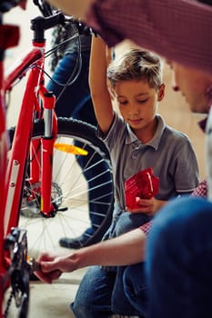 Little boy helping his father in garage