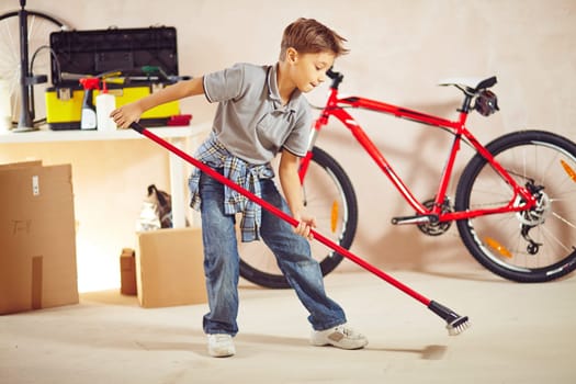 Cute lad doing cleanup in garage