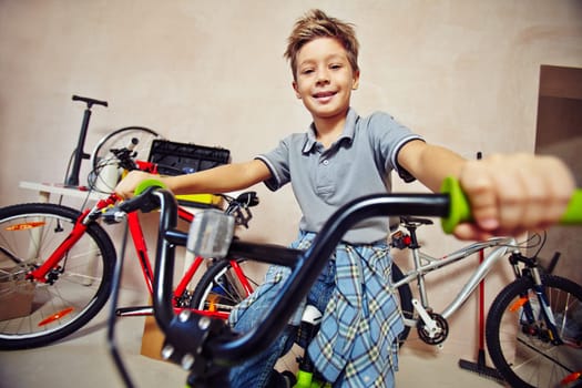 Adolescent boy in casualwear sitting on bicycle