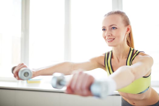 Young woman exercising with dumbbells