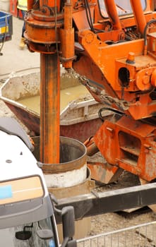 A construction site with tools and materials as well as a drill rod that drills a borehole.