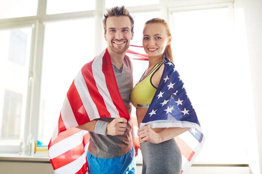 Young sporty couple wrapped in USA flag
