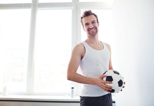 Portrait of happy young man with soccer ball
