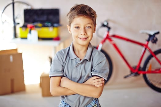 Little boy with crossed arms looking at camera in garage