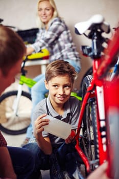 Handsome boy lubricating bike wheel chain with special oil