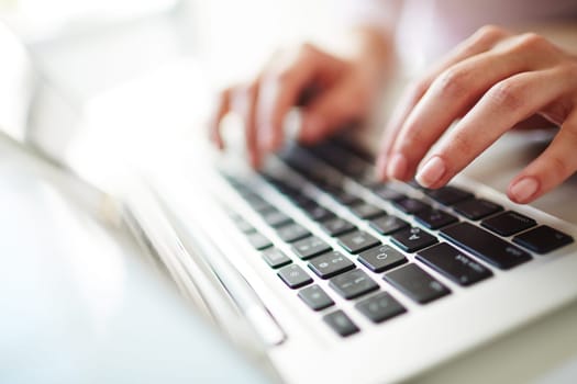 Fingers of female over laptop keypad