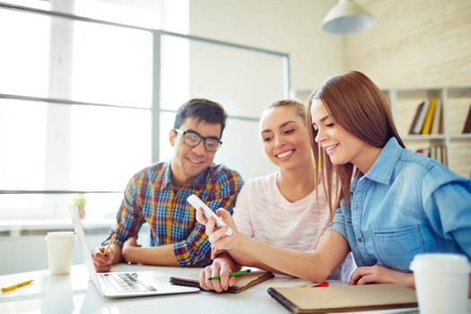 Group of happy teenagers browsing in smartphone