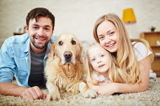 Happy young couple, their daughter and dog