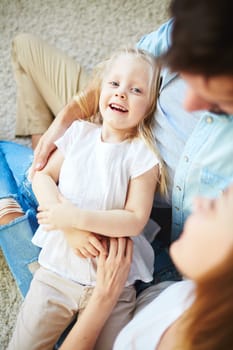 Happy little girl enjoying rest with her parents
