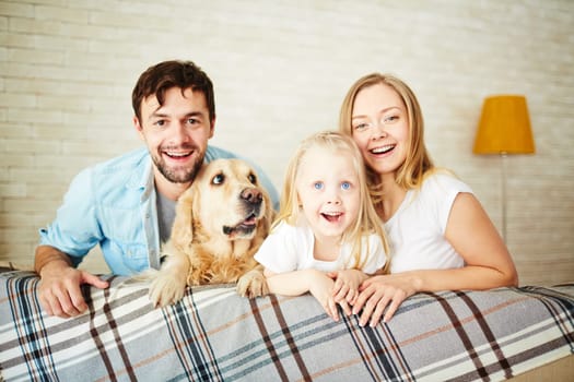 Parents, their daughter and dog staying at home