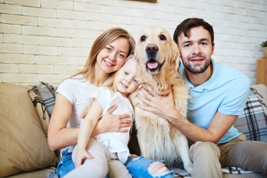 Modern family and their cute pet resting at home