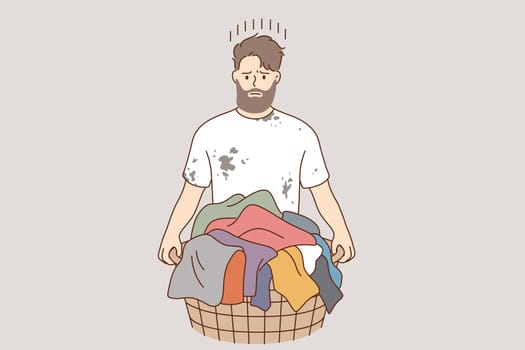Laundry and washing clothes concept. Young frustrated stressed man cartoon character standing and holding basket with dirty colorful clothes for laundry vector illustration