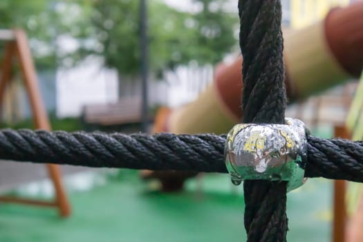 A courtyard of high-rise buildings with a modern and large playground made of wood and plastic on a rainy summer day without people. Empty outdoor playground. A place for children's games and sports