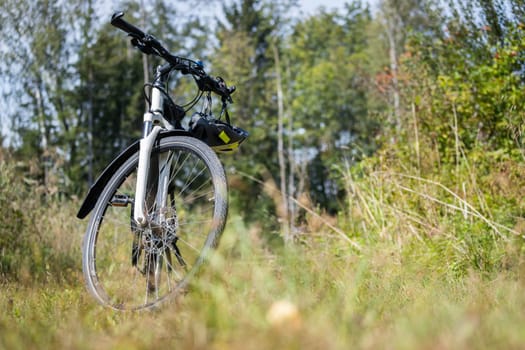 Bike tour. Bike, grass and wood. Outdoors, text space