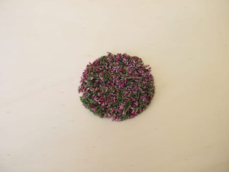 Dried heather herb with leaves and flowers on a wooden board