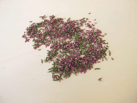 Dried heather herb with leaves and flowers on a wooden board