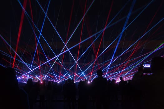 blue laser lights and people silhouettes at concert