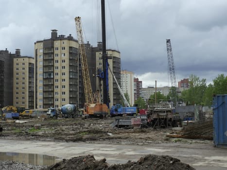 St. Petersburg  Russia  May 23, 2021. View of the construction site, construction machinery against the backdrop of newly built residential buildings