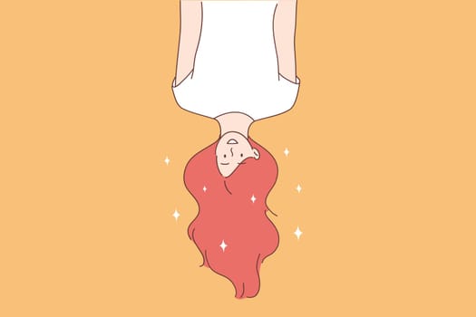 Cheerful and positive emotions concept. Beautiful red haired young woman cartoon character hanging upside down with hair down over yellow background vector illustration