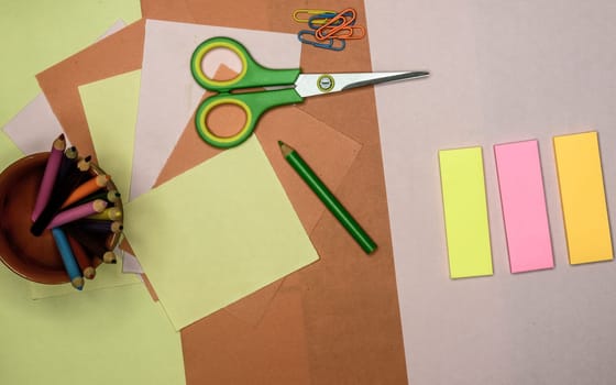 Set of tools for Scrapbook Artist and Paper Crafter. Colour paper, scissors, pencils, paint, and ruler on table. DIY Paper Crafts making creative background. Flat lay.