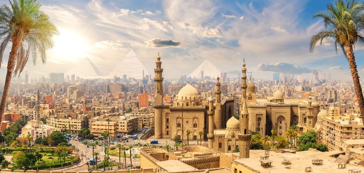 Mosque-Madrasa of Sultan Hassan behind the palm trees, Cairo, Egypt.