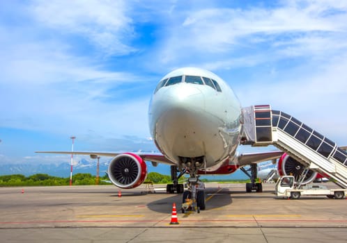 The Airplane with a passenger boarding steps on the airport apron