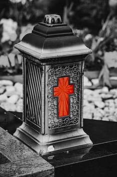 Old damaged grave lantern on a gravestone